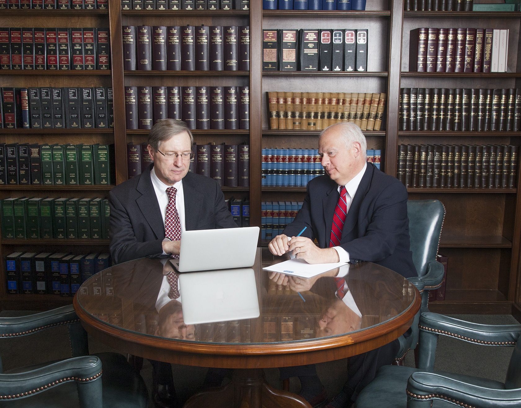 Two attorneys reviewing documents in a law library
