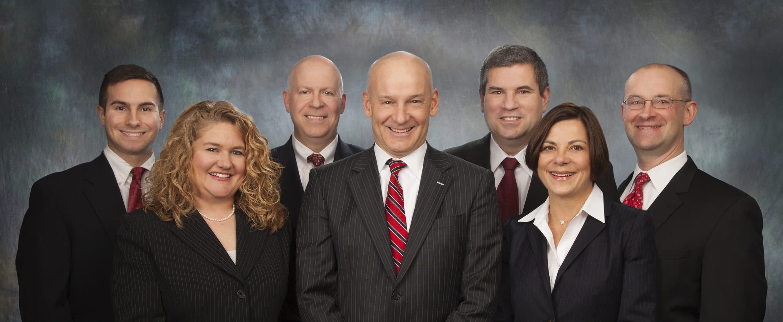 Executive team group portrait on a blue backdrop