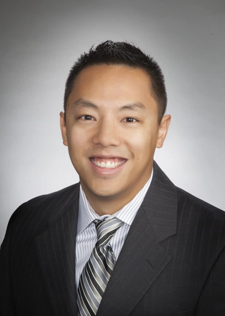 Corporate headshot on a soft gray backdrop from a matched company team set