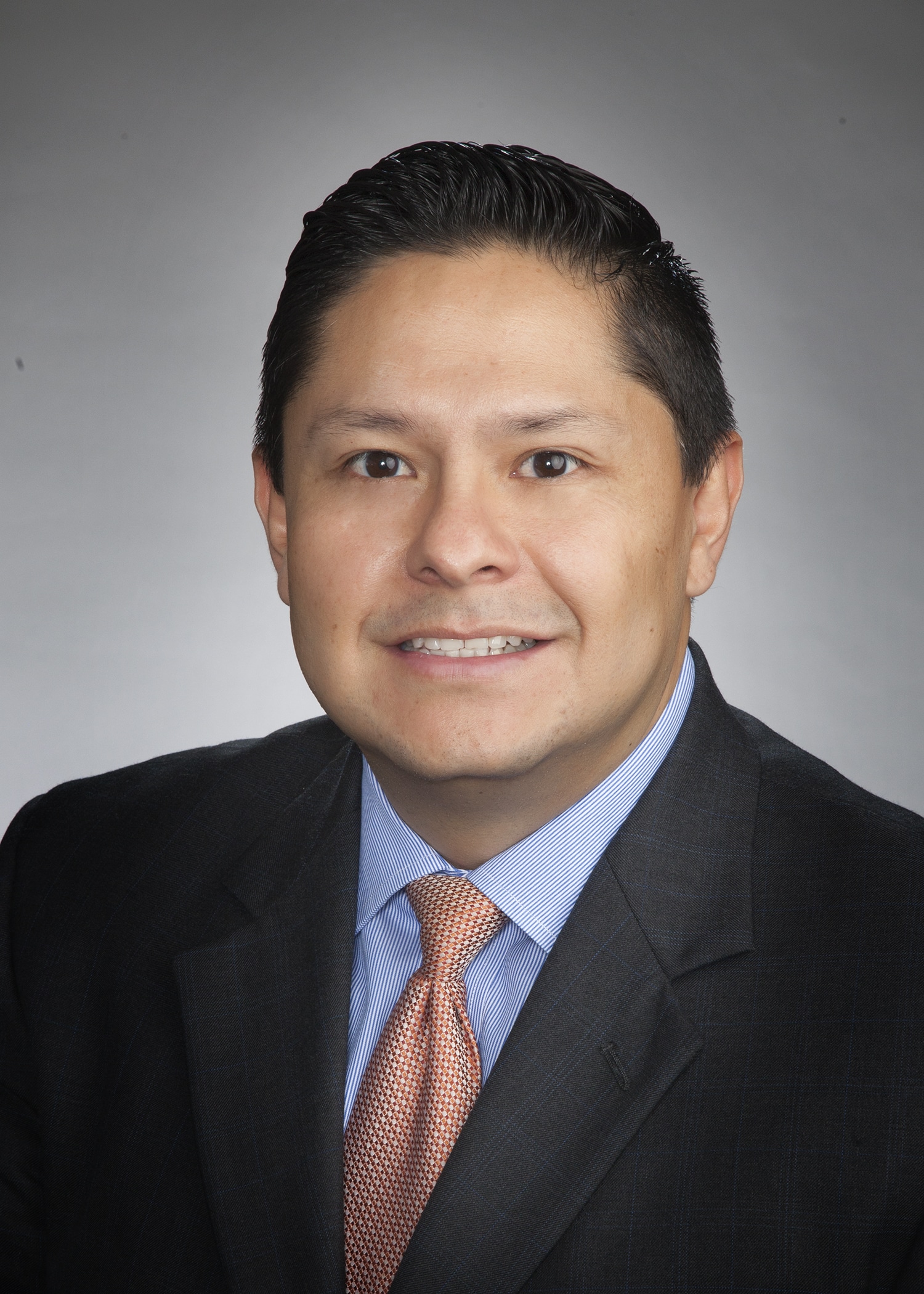Corporate headshot on a soft gray backdrop from a matched company team set