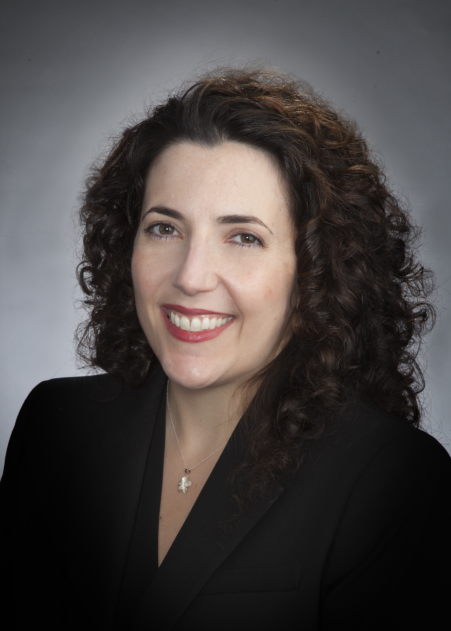 Corporate headshot on a soft gray backdrop from a matched company team set