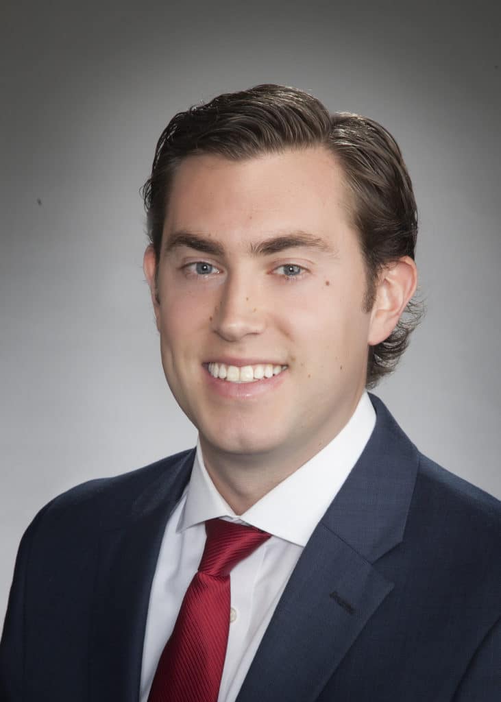 Corporate headshot on a soft gray backdrop from a matched company team set