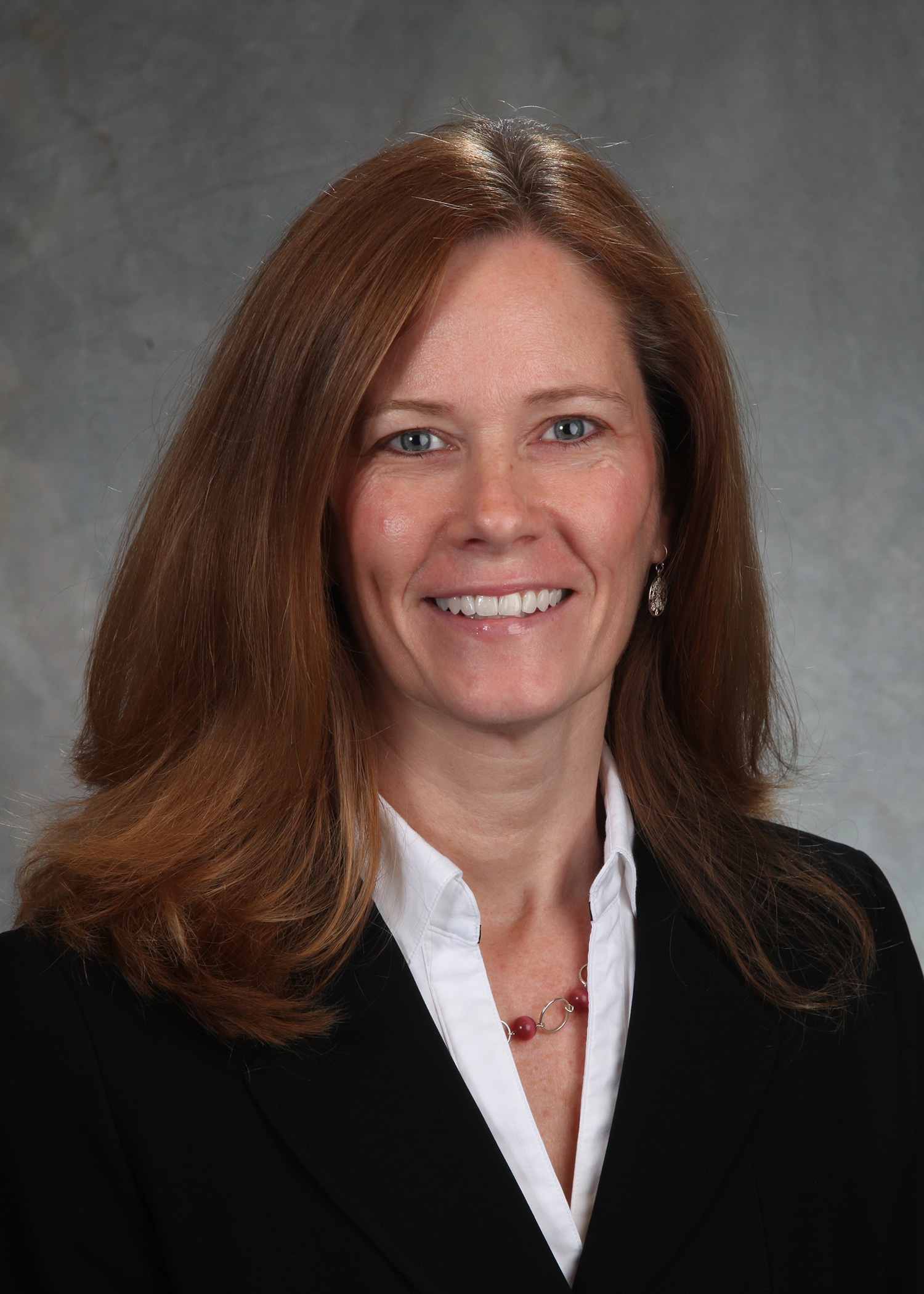 Corporate headshot on a soft gray backdrop from a matched company team set
