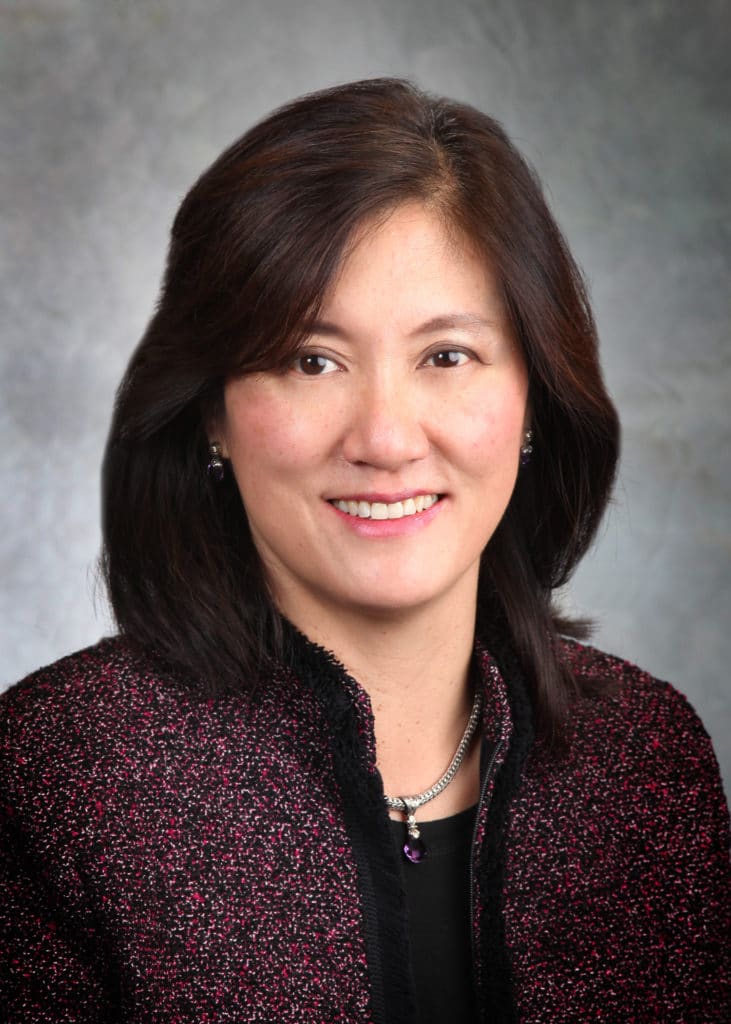 Corporate headshot on a soft gray backdrop from a matched company team set