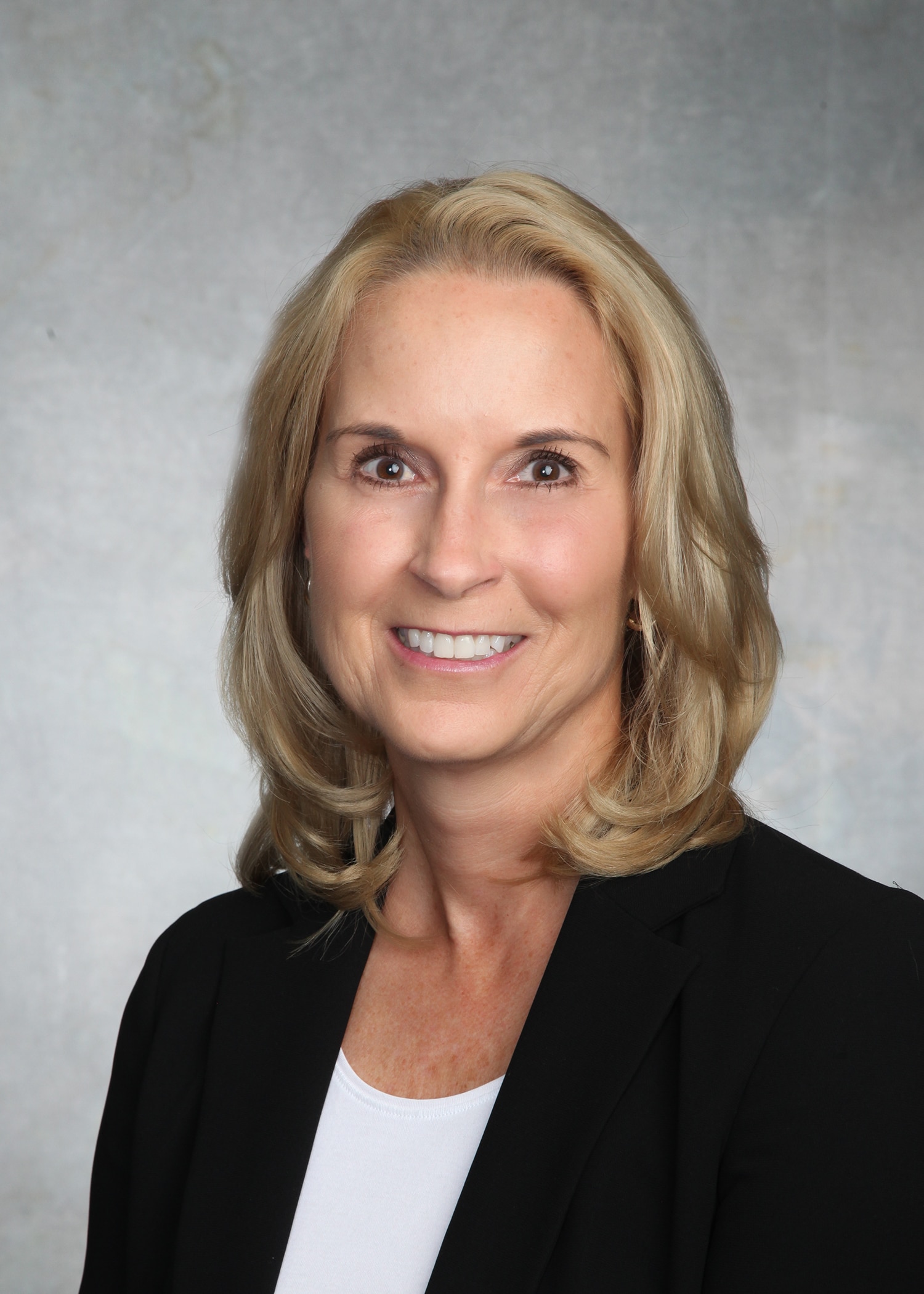 Corporate headshot on a soft gray backdrop from a matched company team set