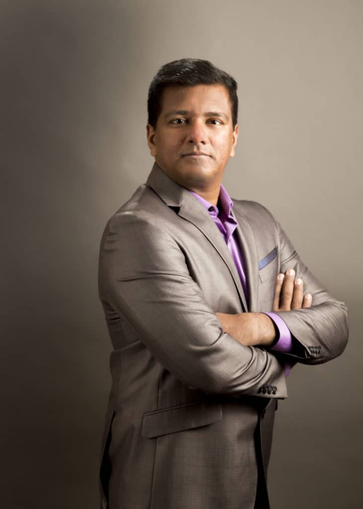 Executive portrait with arms crossed on a warm backdrop