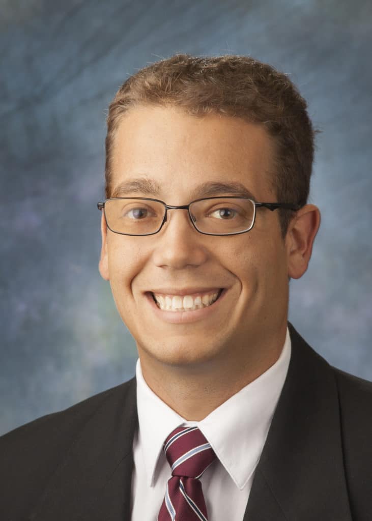 Attorney headshot on a blue backdrop for a law firm website