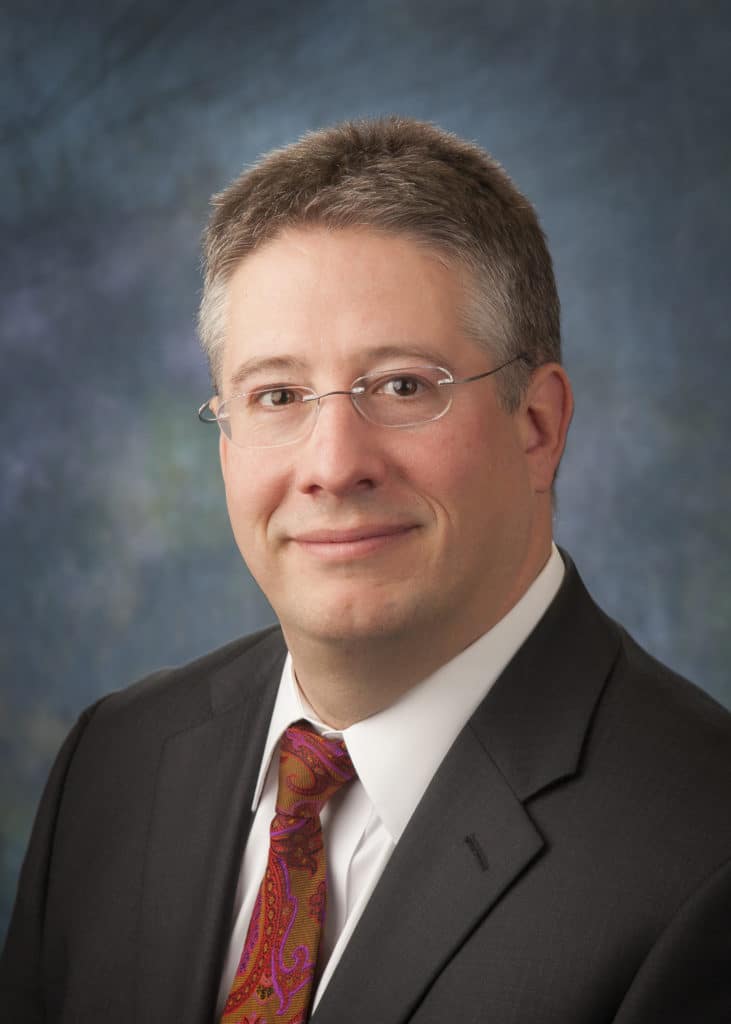 Attorney headshot on a blue backdrop for a law firm website
