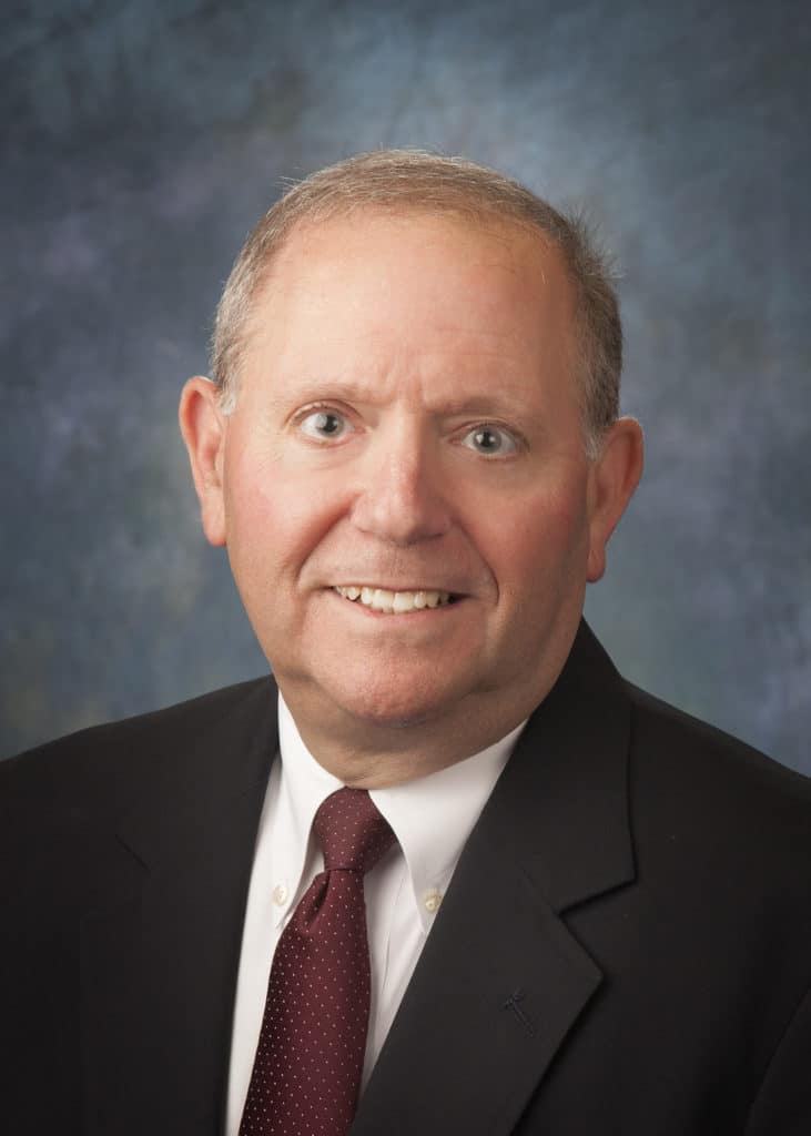 Attorney headshot on a blue backdrop for a law firm website