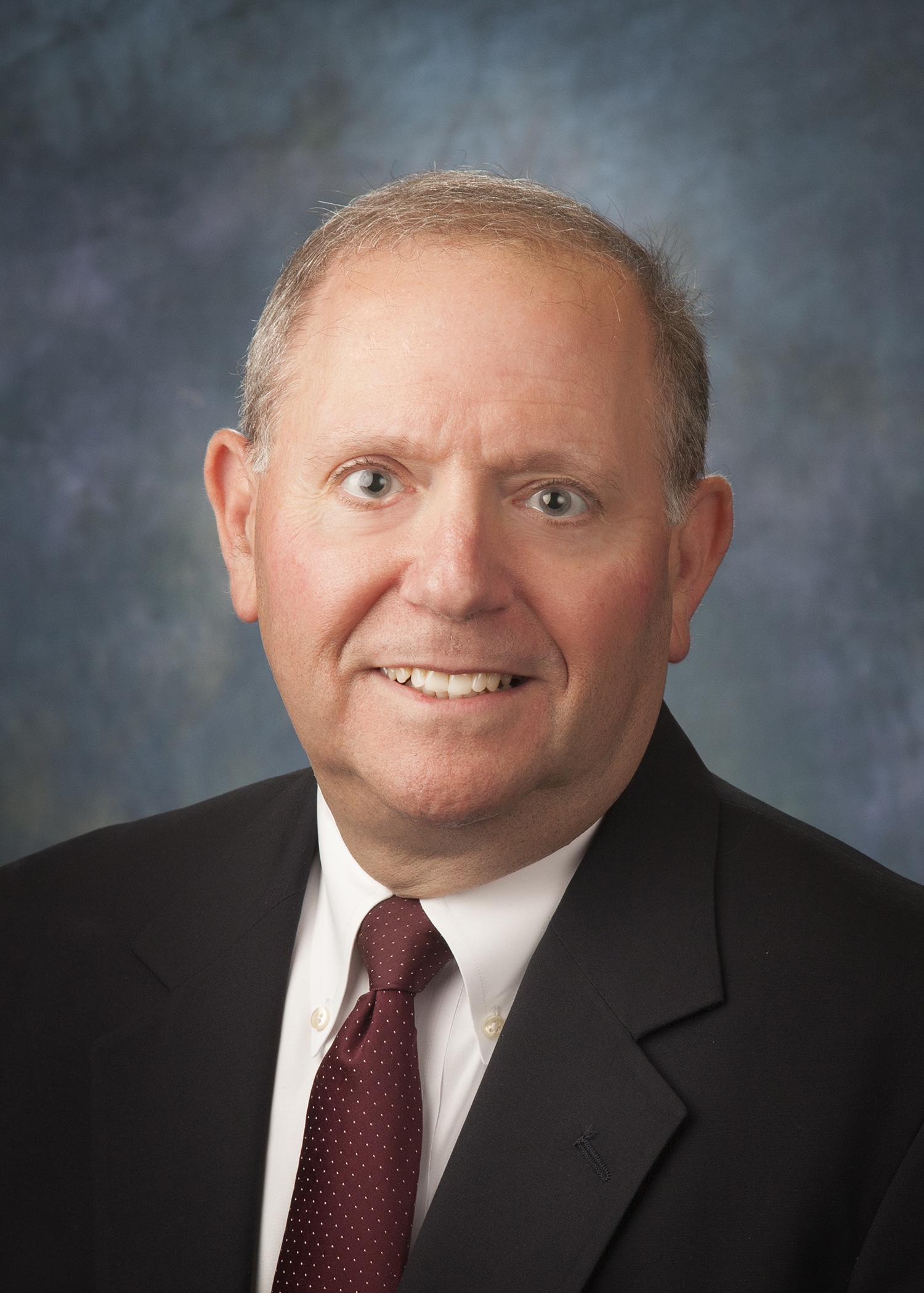 Attorney headshot on a blue backdrop for a law firm website