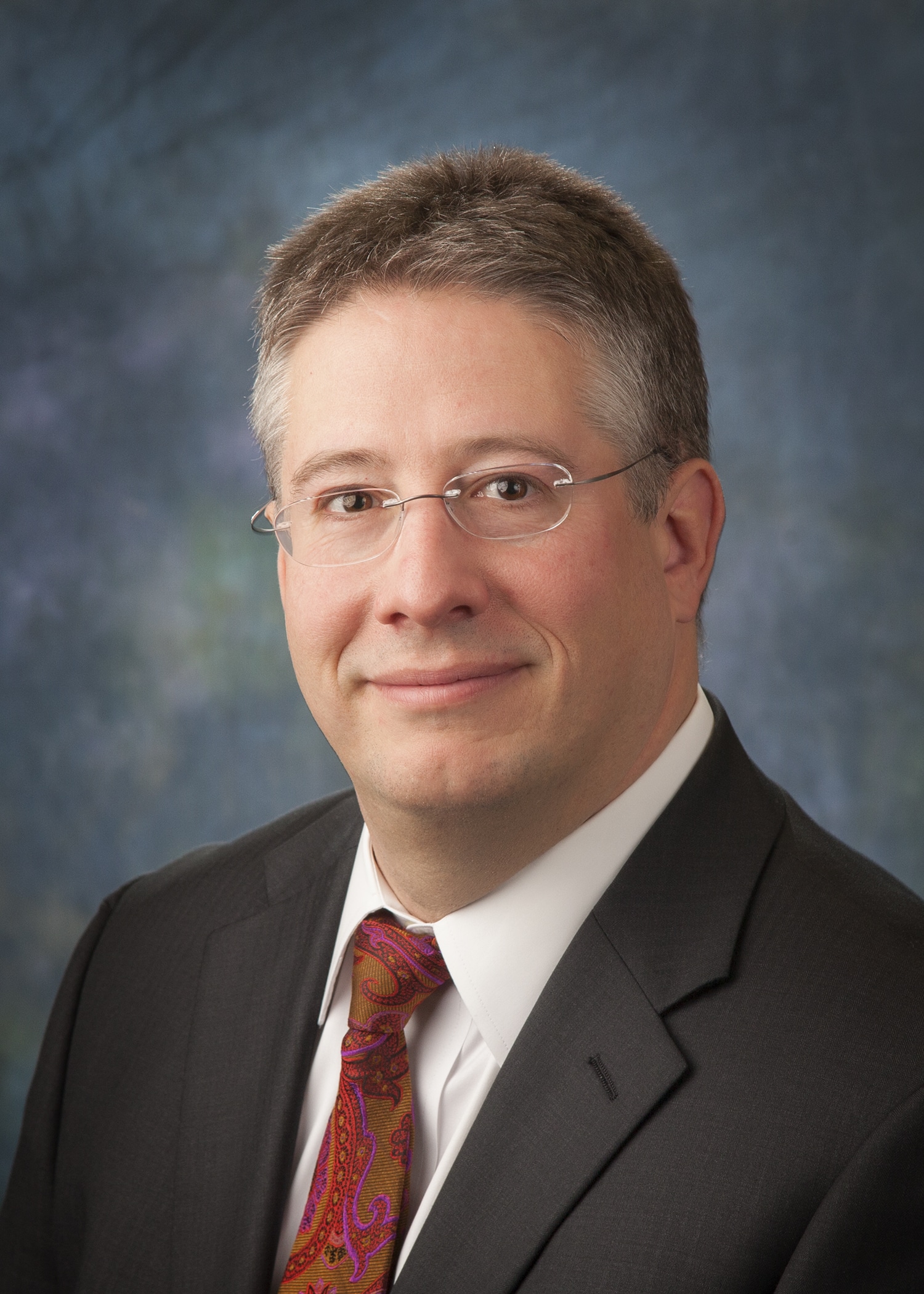Attorney headshot on a blue backdrop for a law firm website