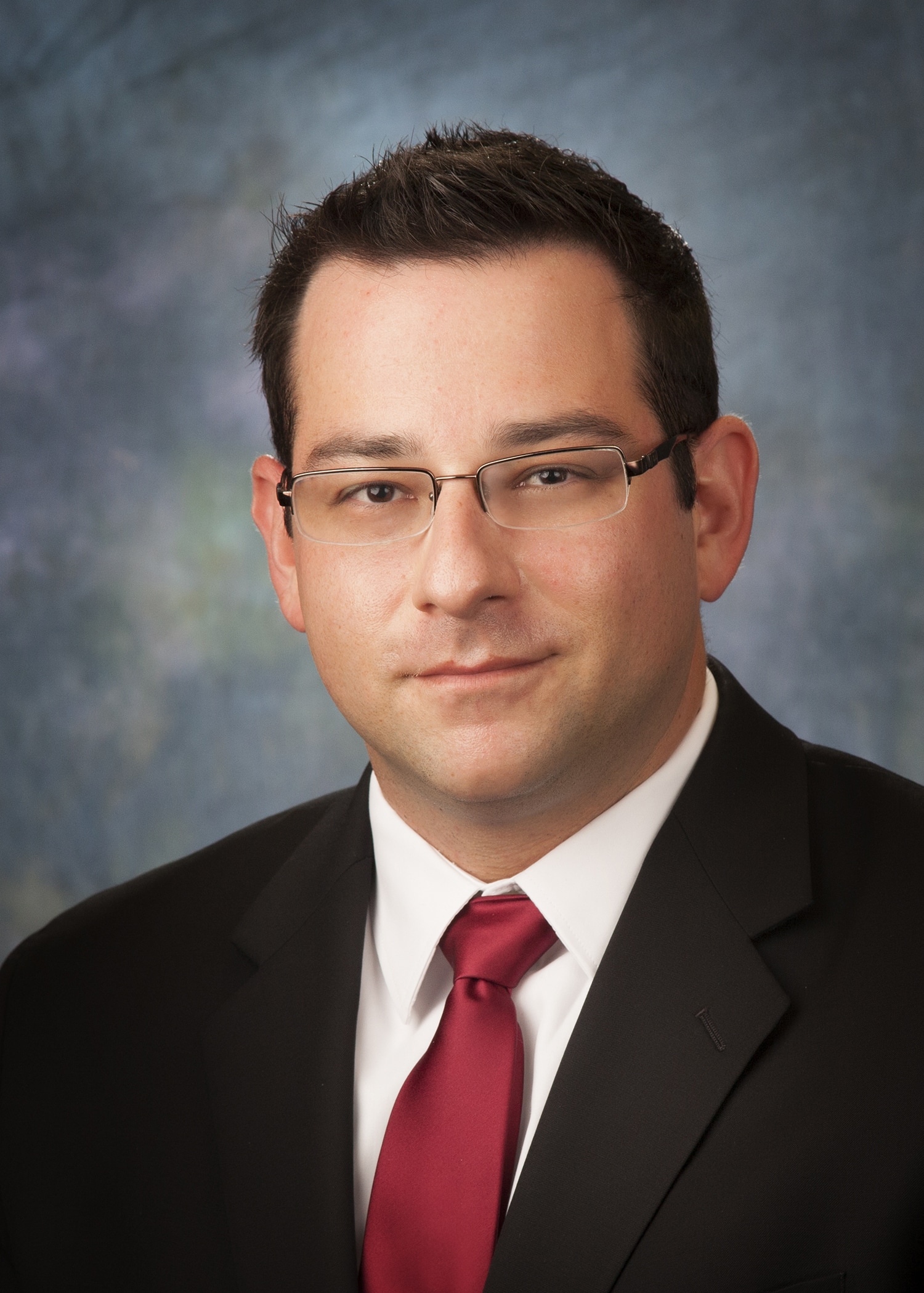 Attorney headshot on a blue backdrop for a law firm website