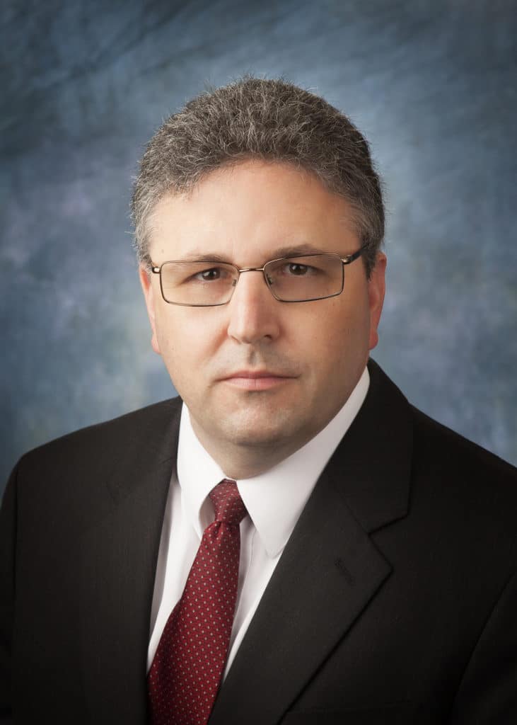 Attorney headshot on a blue backdrop for a law firm website