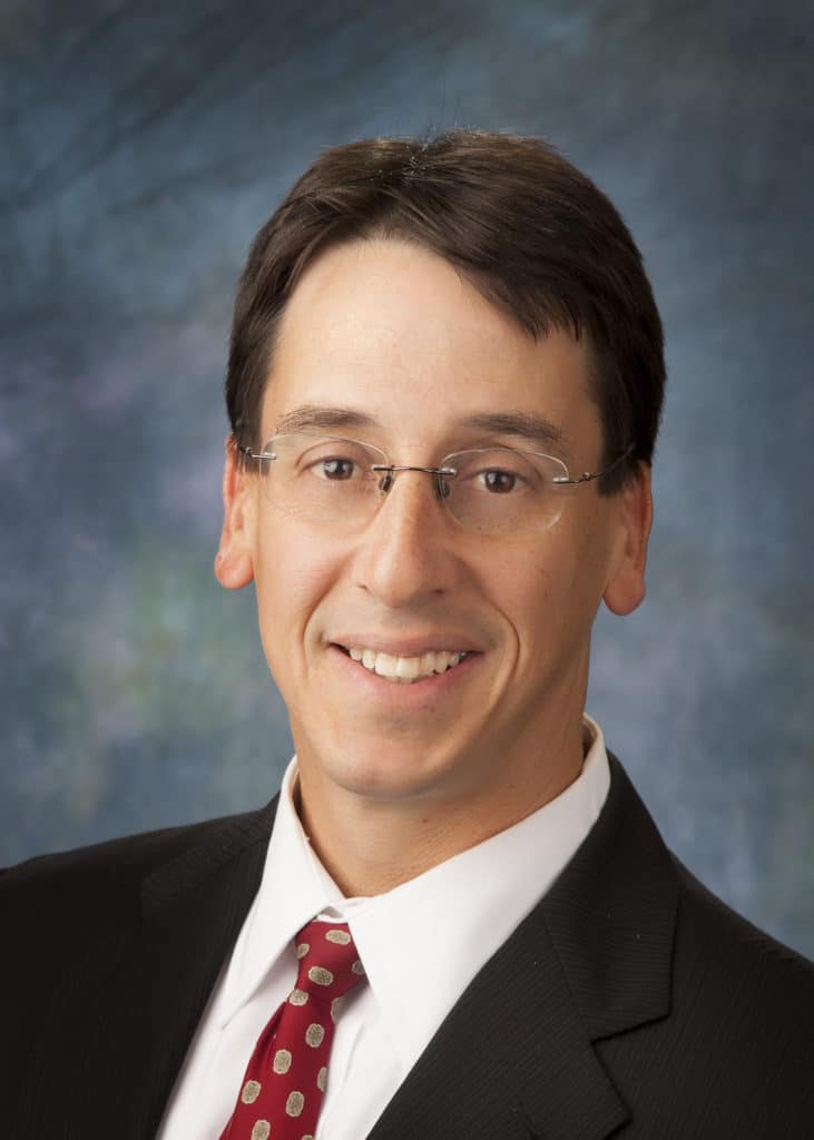Attorney headshot on a blue backdrop for a law firm website