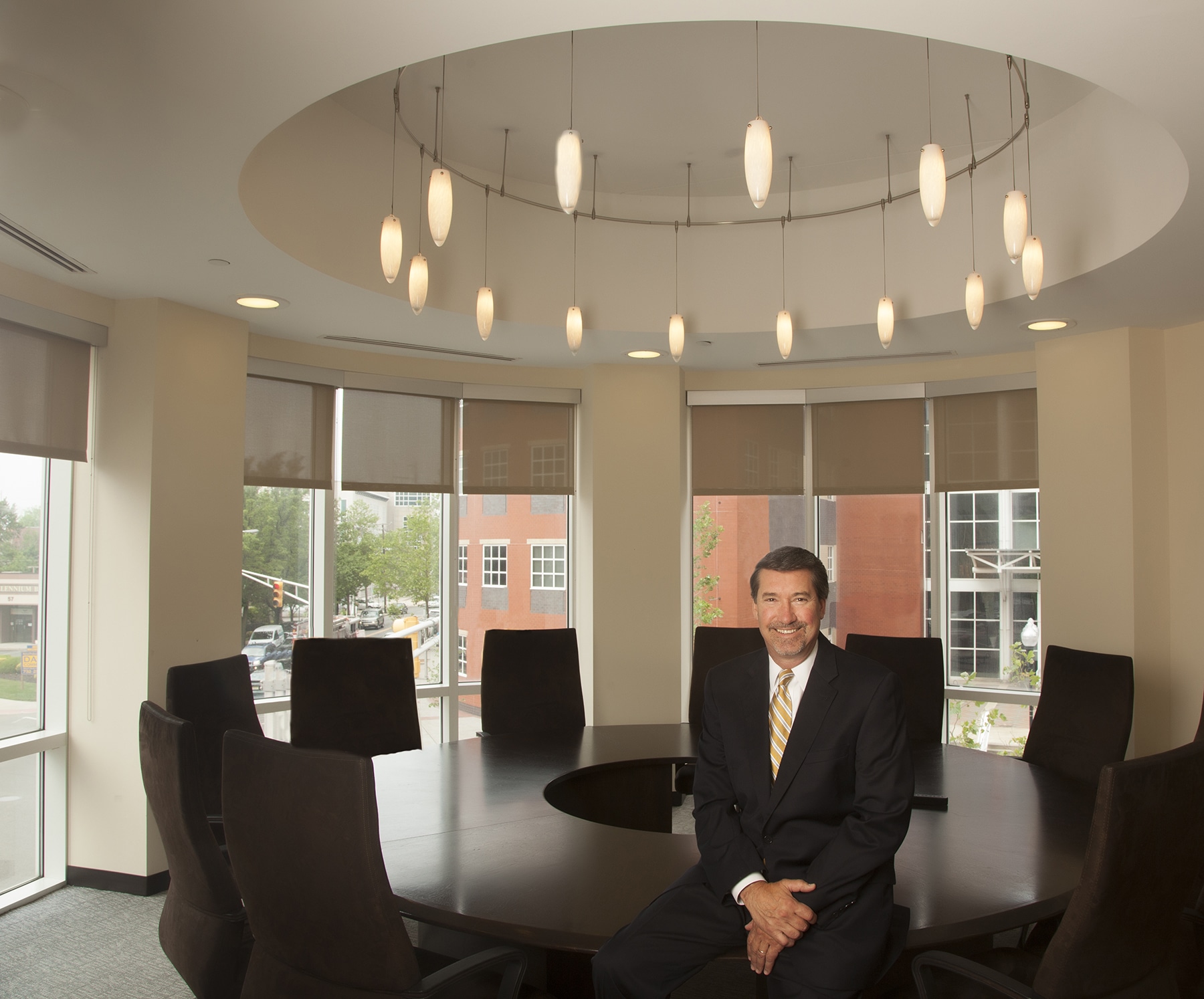 Executive in a round conference room with pendant lights