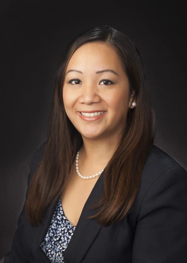 Business headshot on a dark gray backdrop