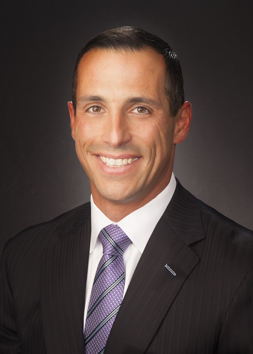 Business headshot on a dark gray backdrop