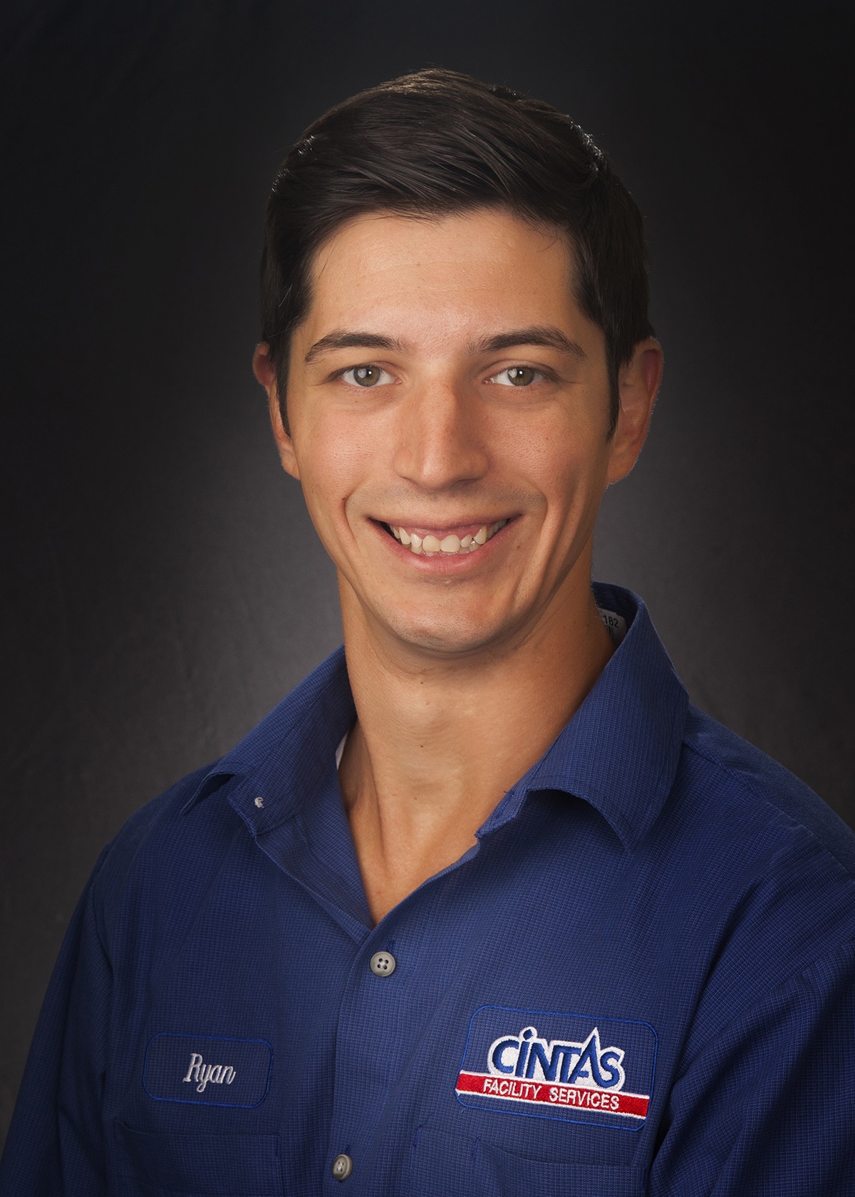Employee headshot in a company uniform, photographed on location for a staff directory