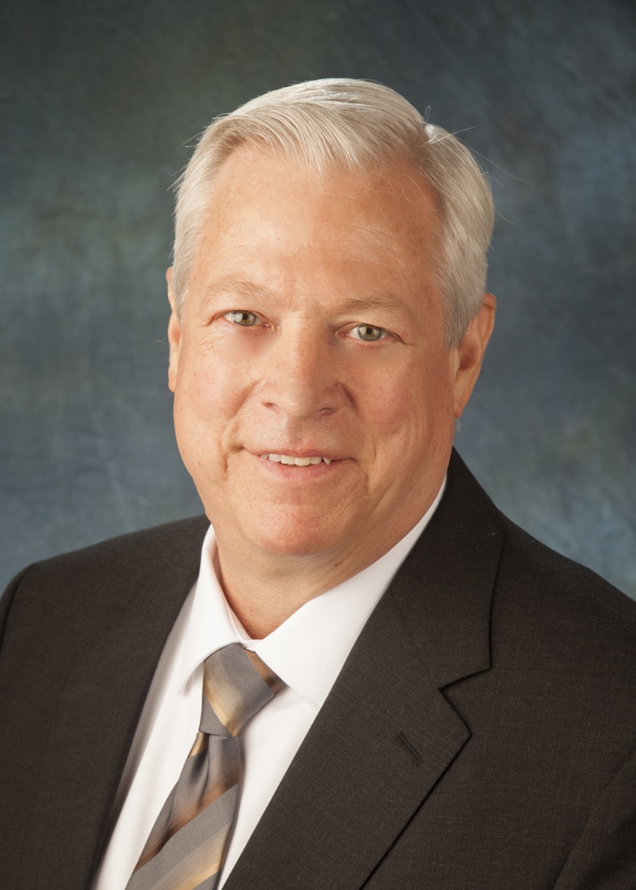 Staff headshot on a blue-gray backdrop for a company website and directory
