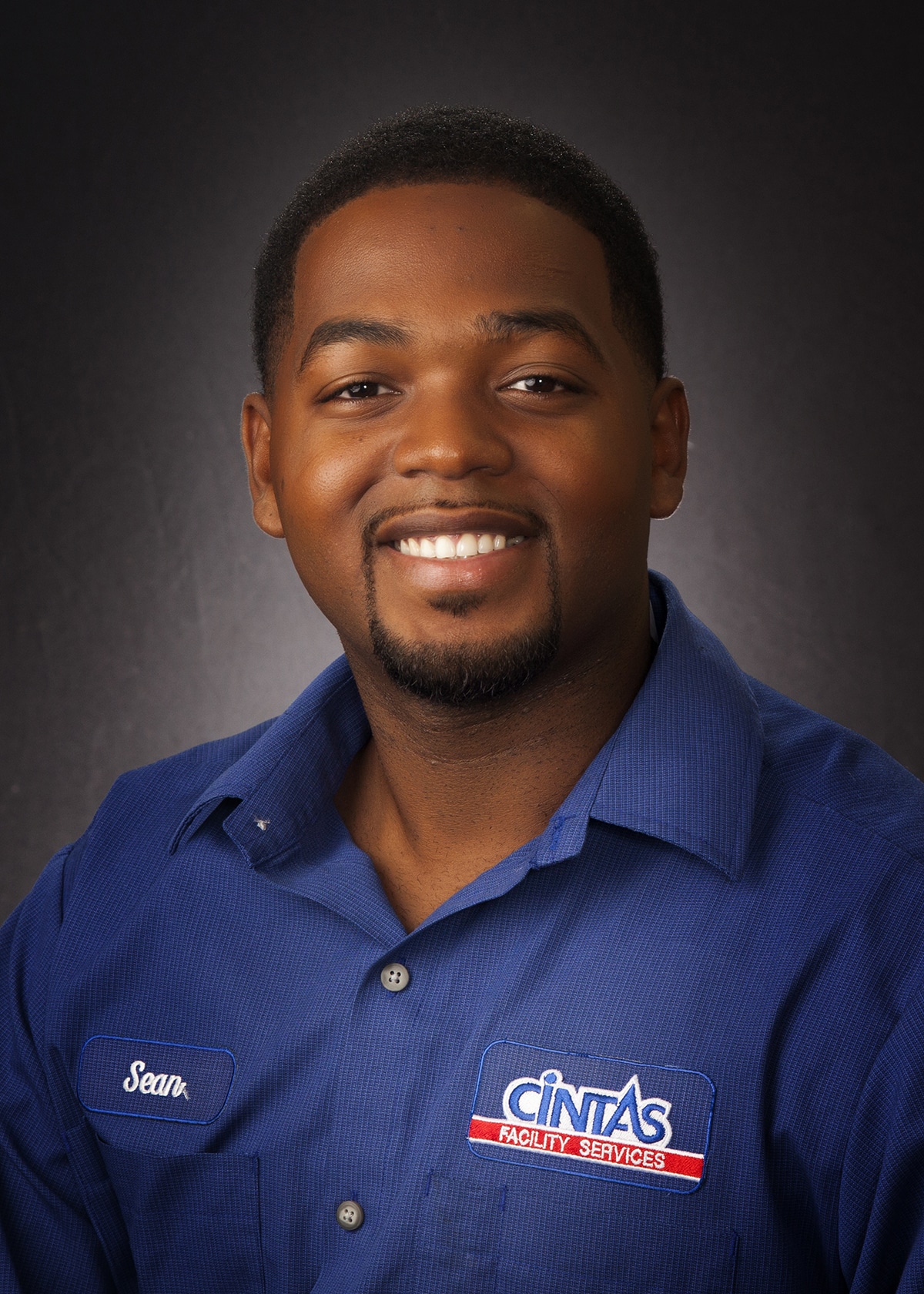 Employee headshot in a company uniform, photographed on location for a staff directory