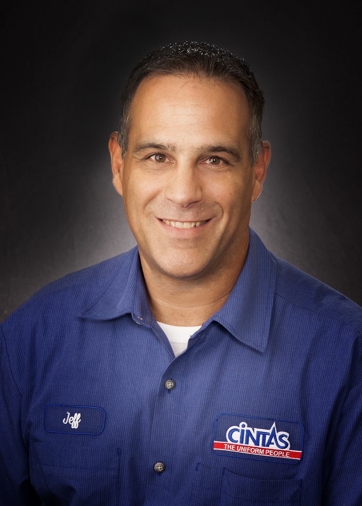Employee headshot in a company uniform, photographed on location for a staff directory