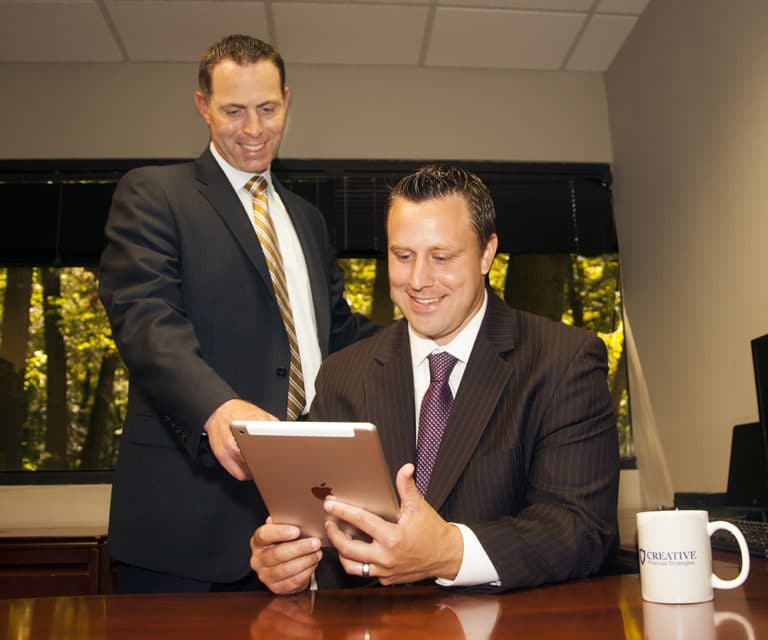 Two executives reviewing a tablet at a conference table