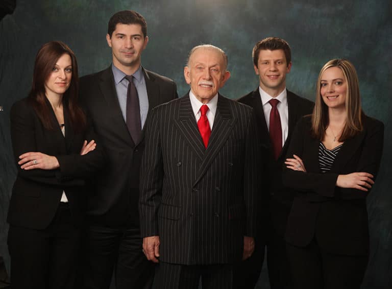 Family business leadership group portrait on a dark backdrop