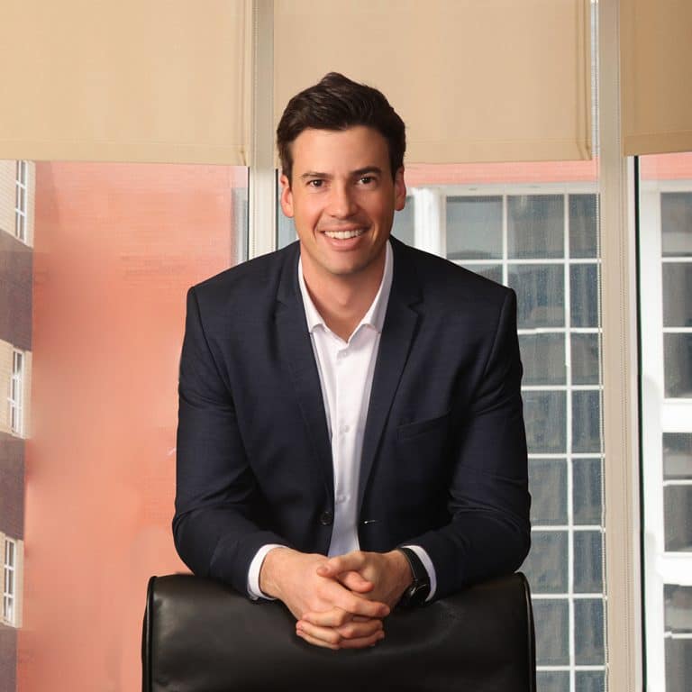 Executive seated in an office with city windows