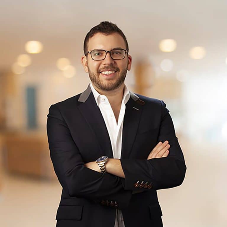 Executive portrait with arms crossed in a bright office