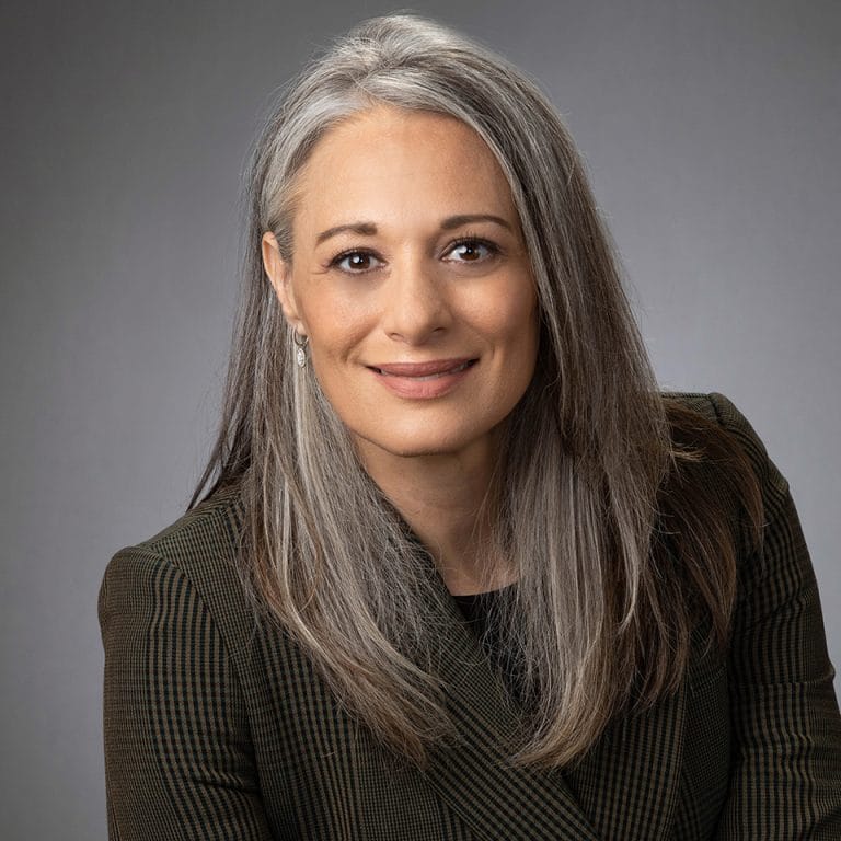 Studio headshot on a neutral gray backdrop