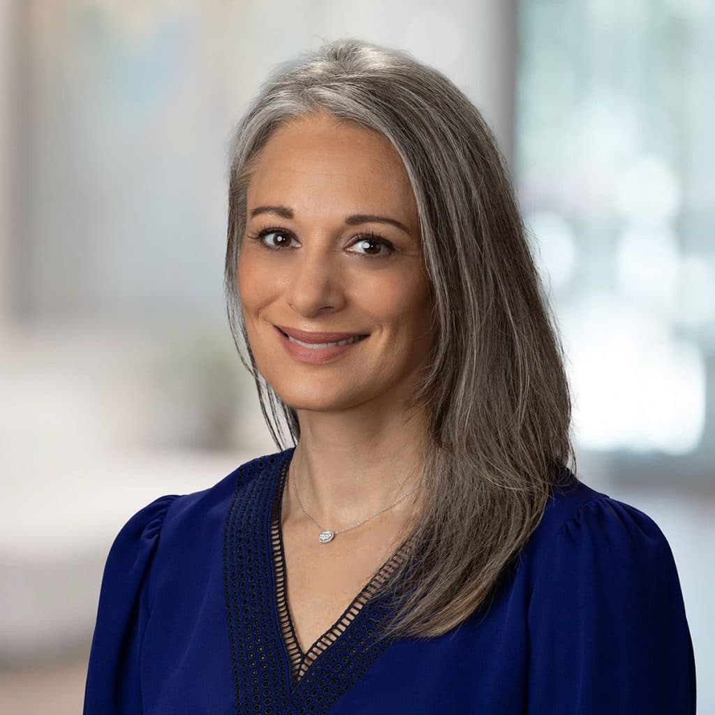 Studio headshot of a woman in front of soft window light